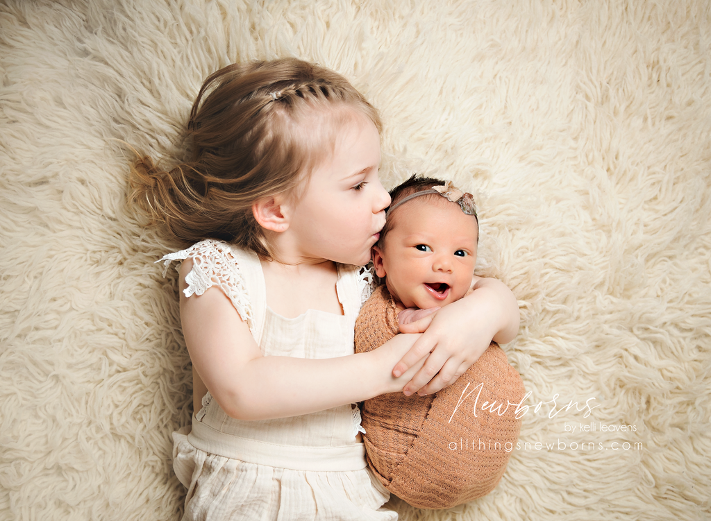 Sibling in cream with newborn wrapped in terracotta for coordinated newborn photos