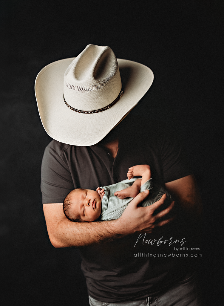 Dad holding newborn baby during a studio newborn photography session