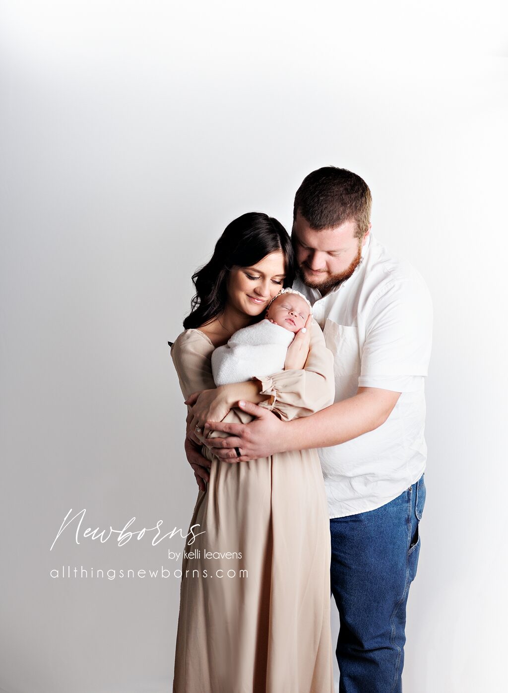 Parents and newborn wearing coordinated earth-tone outfits for newborn photos
