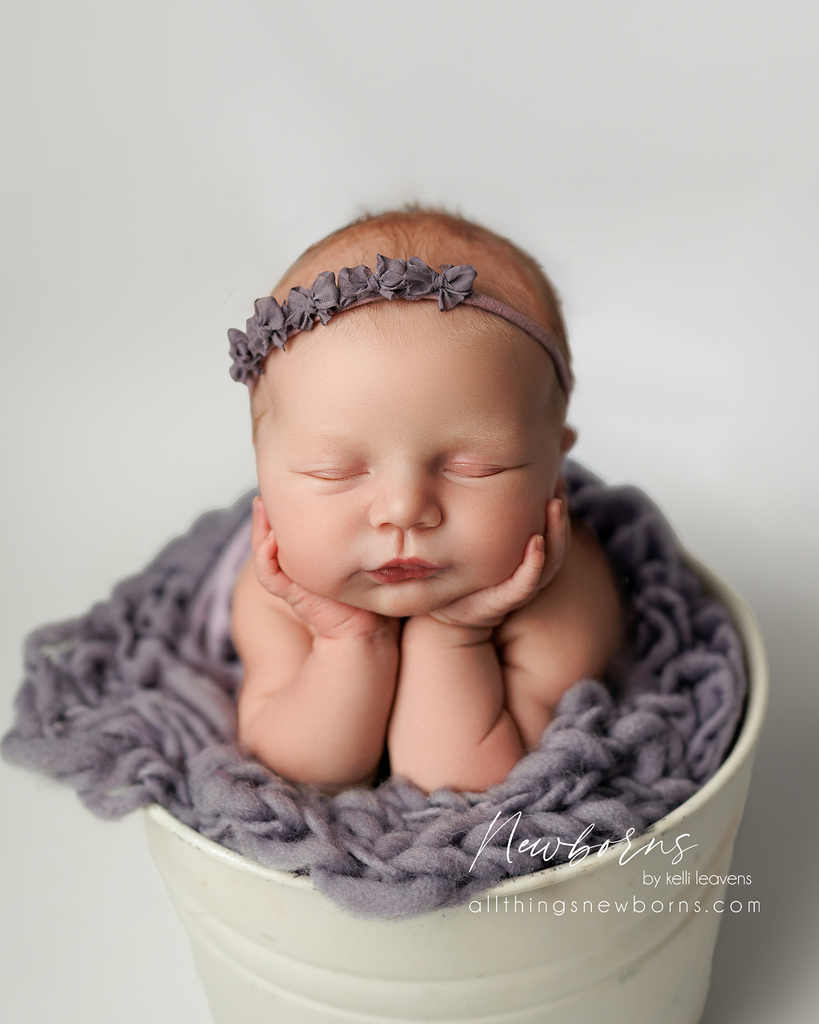 Newborn baby in froggy pose created as a composite with supporting hands for safety